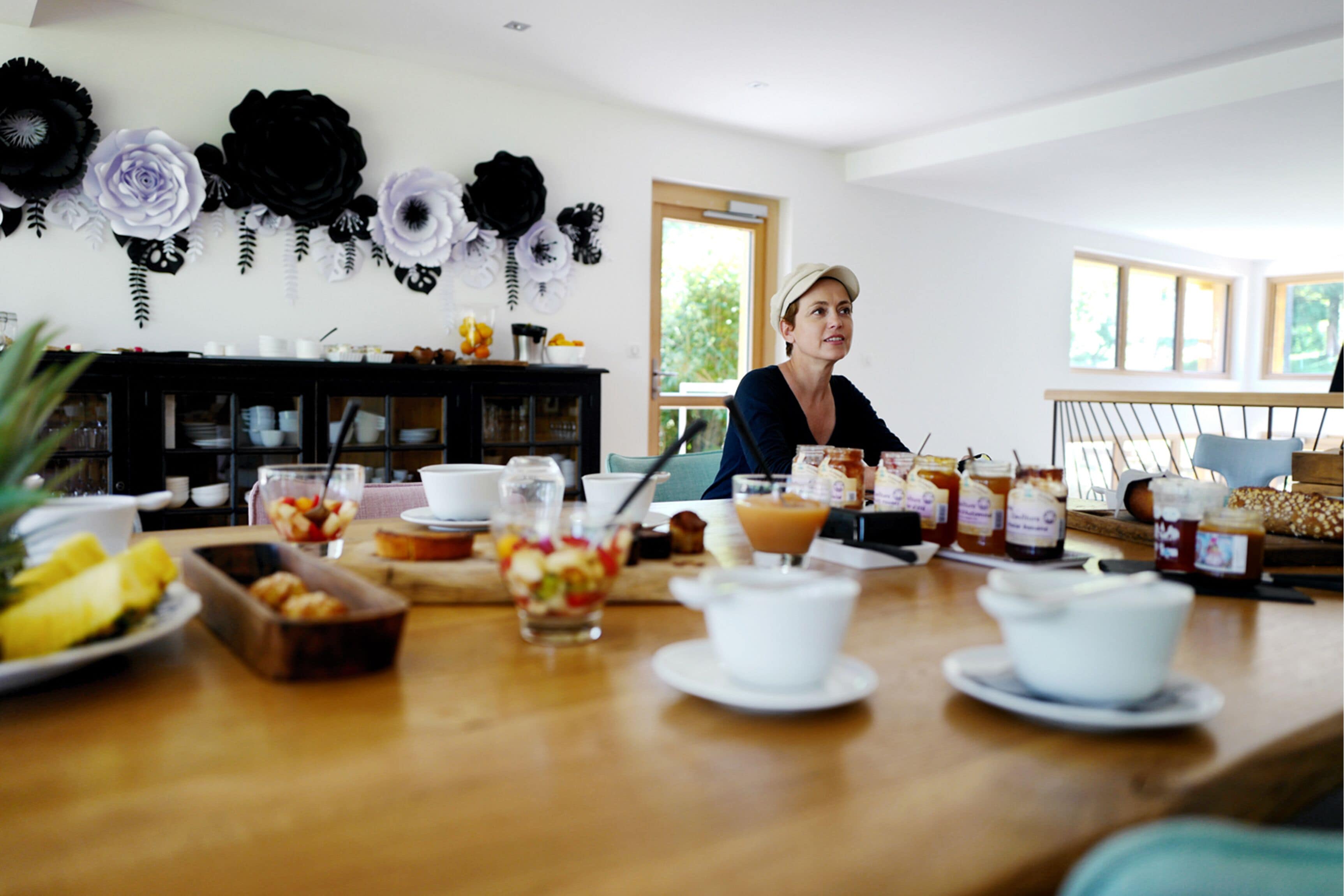 A dining area with a wooden table set for breakfast, including various dishes and condiments.