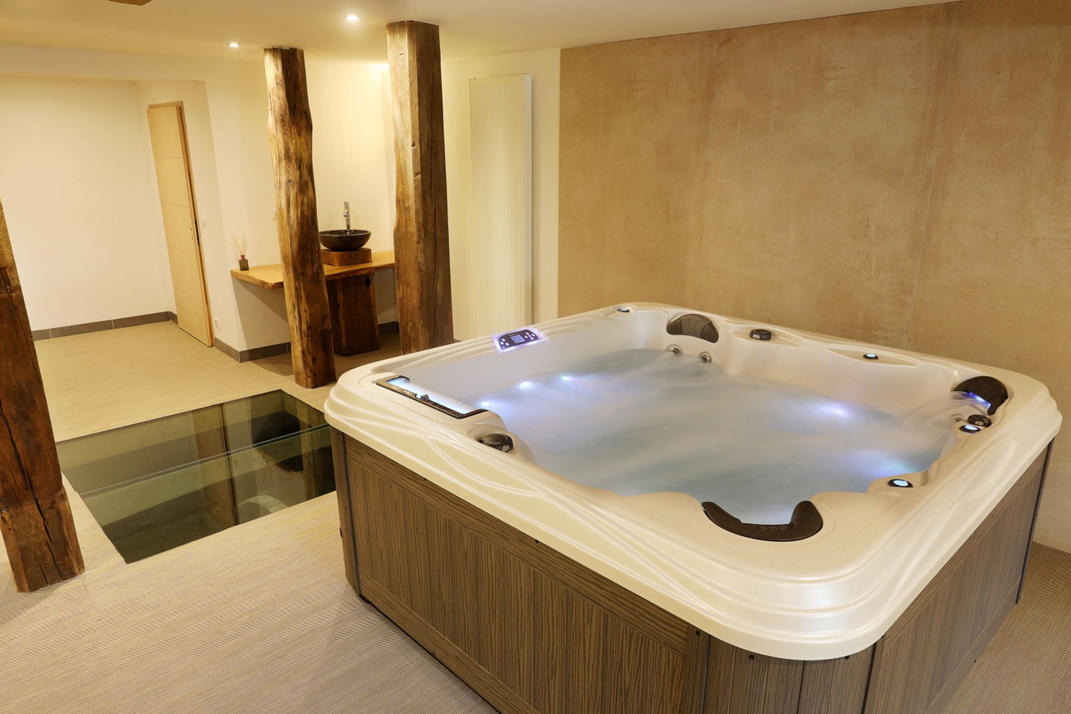 Un bagno moderno con una grande vasca idromassaggio freestanding, dettagli in legno e cabina doccia in vetro.