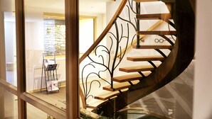 A spiral staircase with wooden steps and a metal railing. - Maison d'hôtes & Spa La Scierie (Salins-les-Bains)