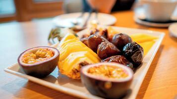 A plate of assorted fruits and nuts on a wooden table.