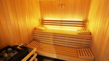 A wooden sauna with benches and a heating element.