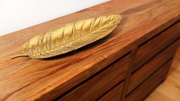 Een houten dressoir met lades en bladgoud decoratie.