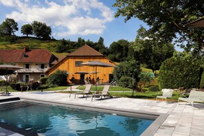 Piscine extérieure en saison, parasols, chaises longues