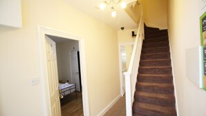 A staircase with carpeted steps leading to a landing. - Flexistay Hillbrook (London)