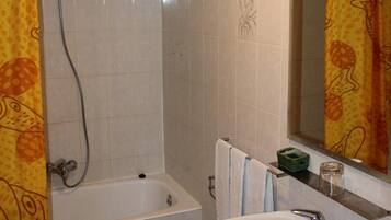 A bathroom with a bathtub, a sink, and a shower.