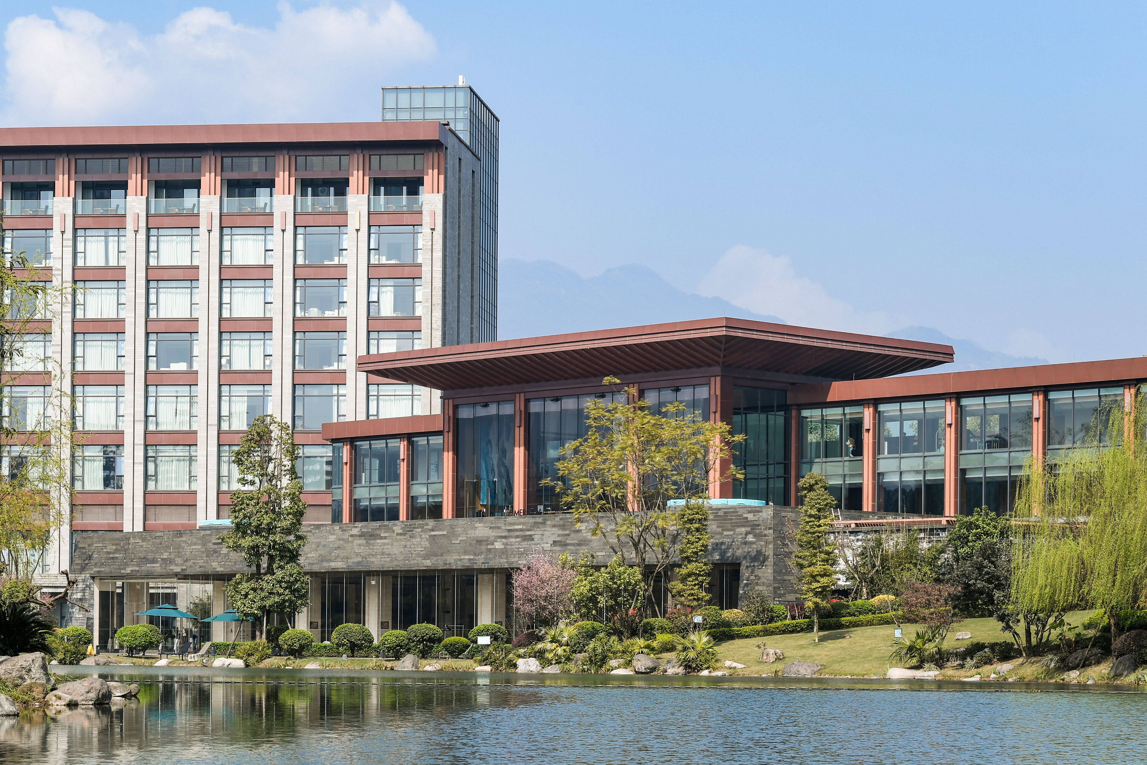 A modern hotel with a large building and a smaller structure in front.