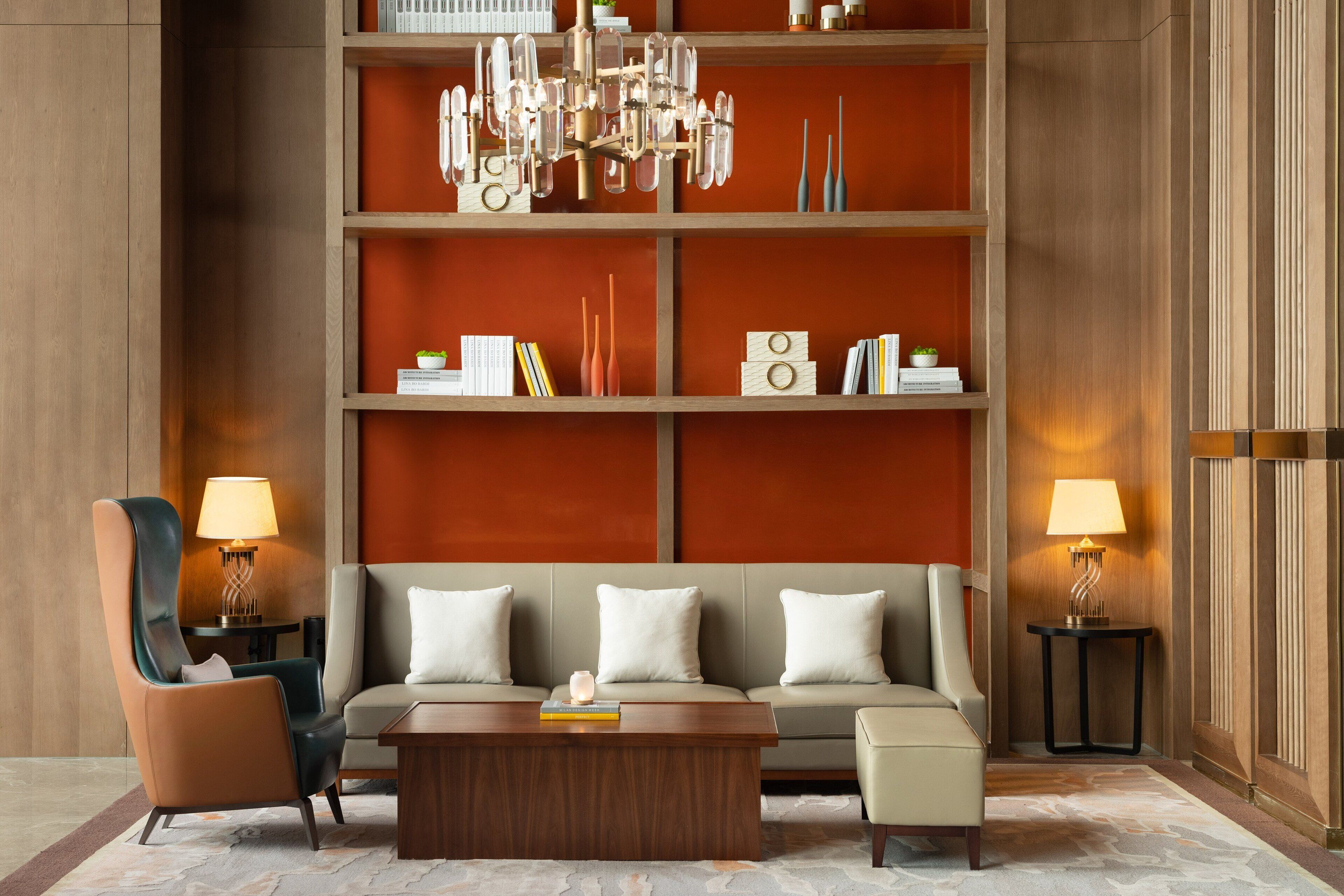 A modern living room with a sofa, armchairs, a coffee table, and a chandelier.