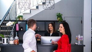 Un comptoir d’accueil avec un ordinateur portable, une plante et un distributeur de bonbons.