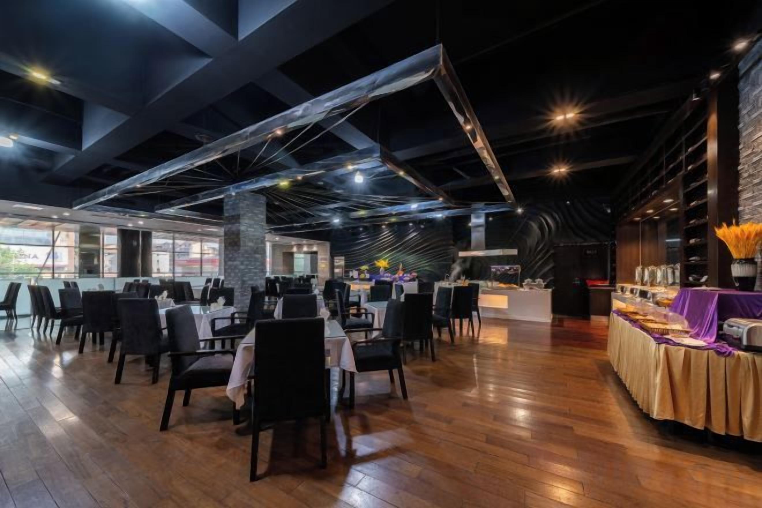 A spacious restaurant with high ceilings, exposed beams, and a variety of seating arrangements.