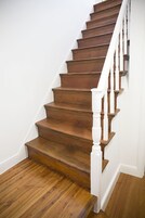 A wooden staircase with white balusters and a white handrail.