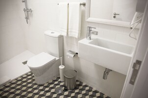 Ein Badezimmer mit Toilette, Bidet, Waschbecken und Mülleimer.