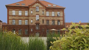 A large brick building with multiple windows and a red-tiled roof. - Amelie N°1 Hotel & Appartements (Landau in der Pfalz)