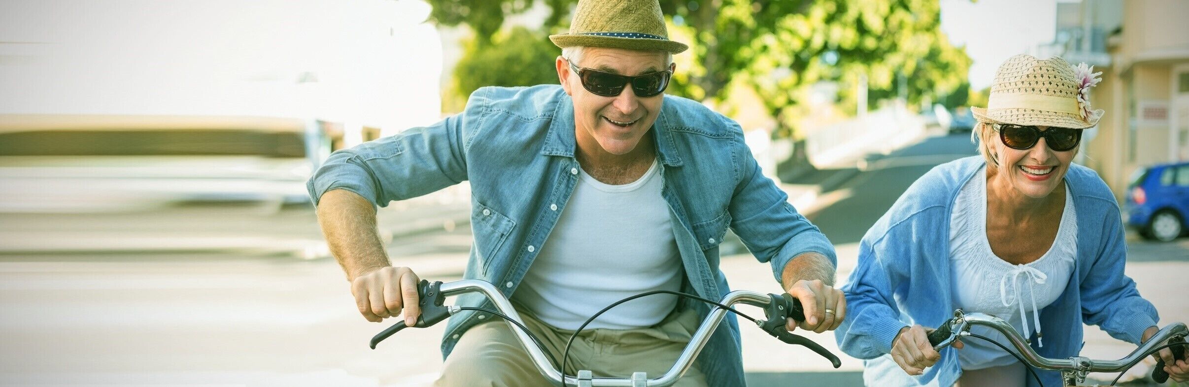 Two people riding a tandem bicycle on a street.