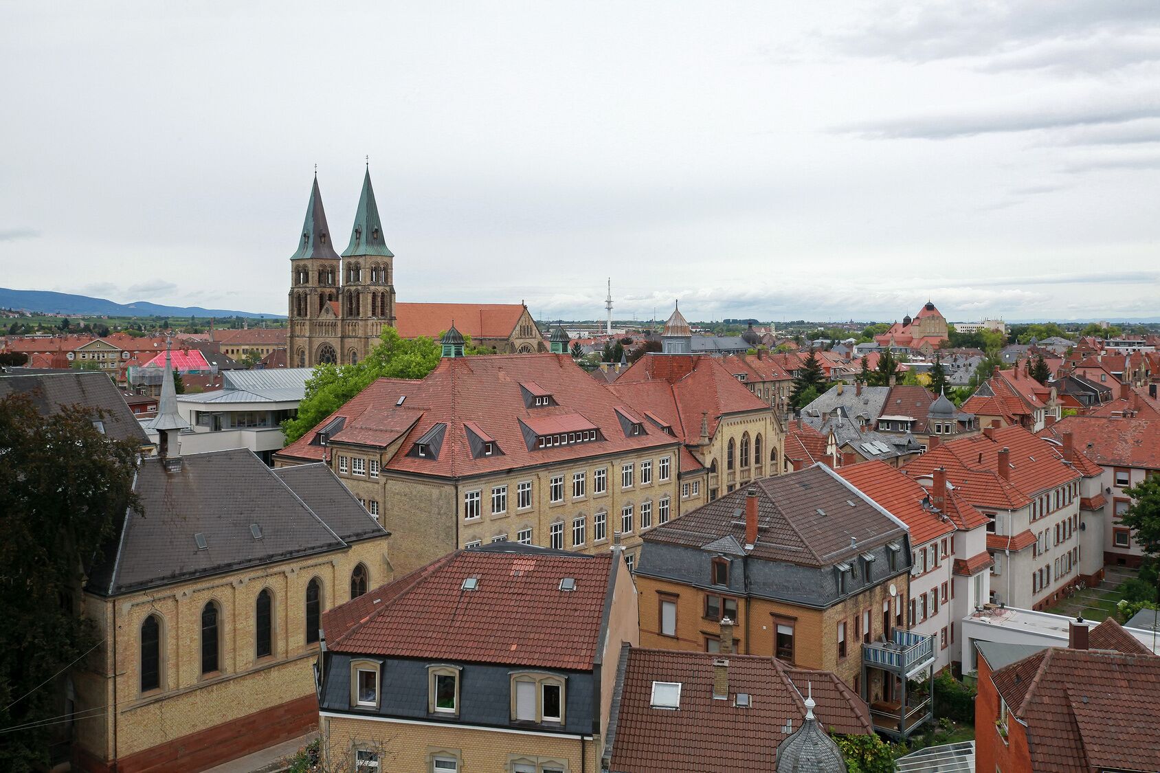 Un pueblo histórico con arquitectura tradicional, incluyendo una iglesia destacada con dos torres y diversos edificios con tejados de tejas rojas.