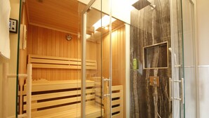 A sauna room with wooden benches and a glass shower enclosure. - Amelie N°1 Hotel & Appartements (Landau in der Pfalz)
