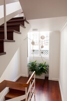 A staircase with wooden steps and white railings leading to a landing.