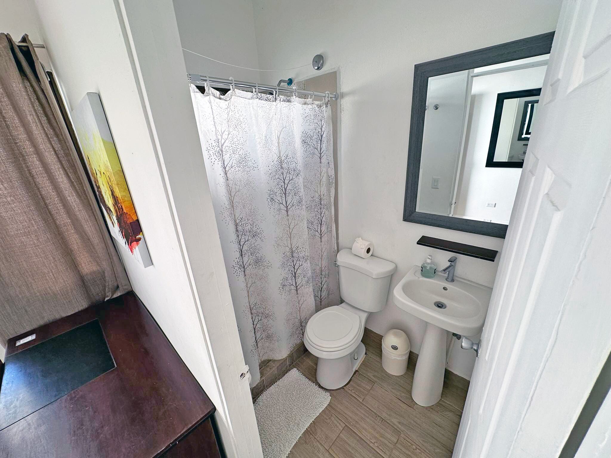 Une salle de bain avec des toilettes, un lavabo et un rideau de douche.