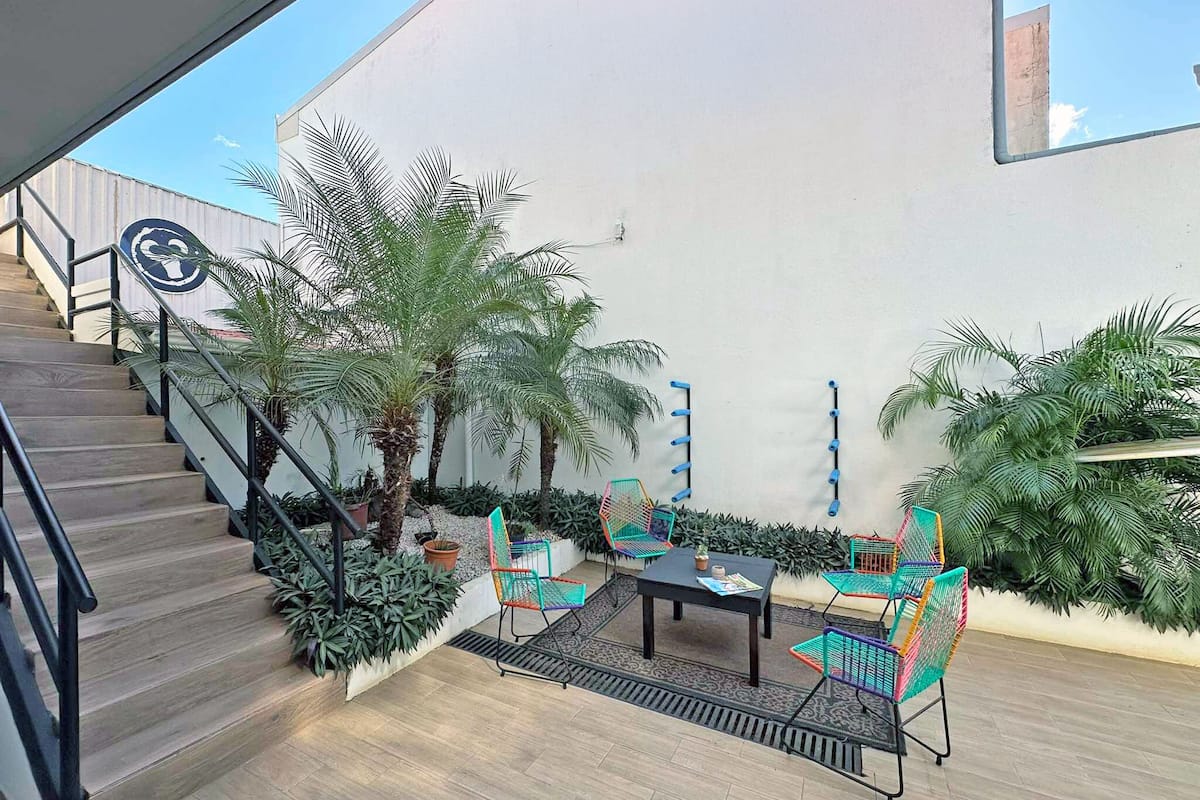 A rooftop patio with a staircase, outdoor seating, and potted plants.