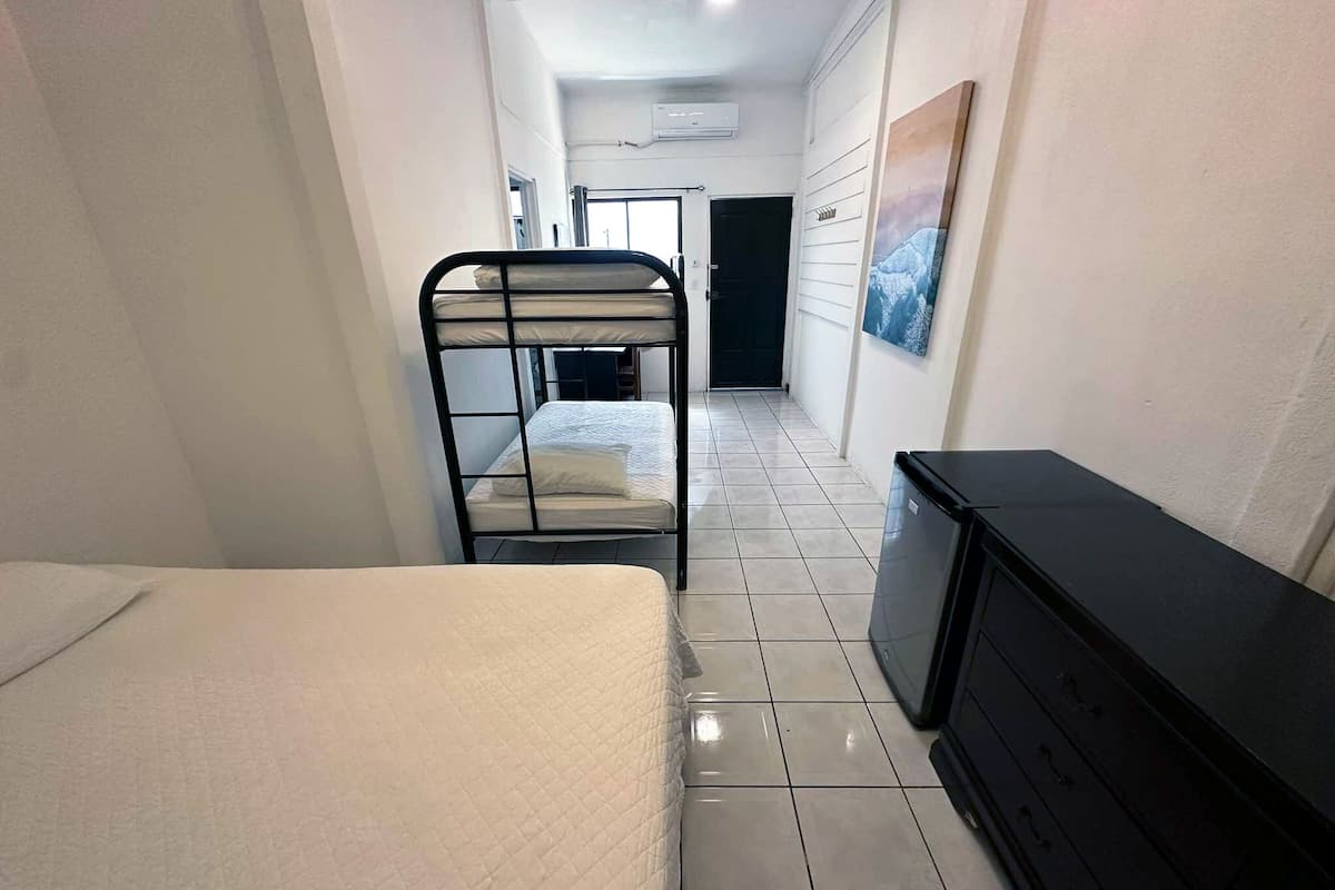 A narrow hallway with a bunk bed and a dresser.