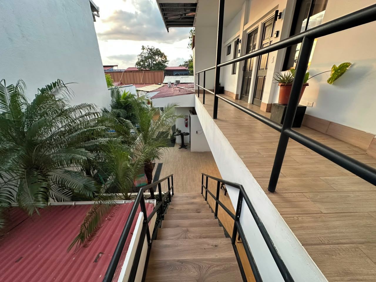 A staircase leading to a second-floor balcony with a view of the surrounding area.