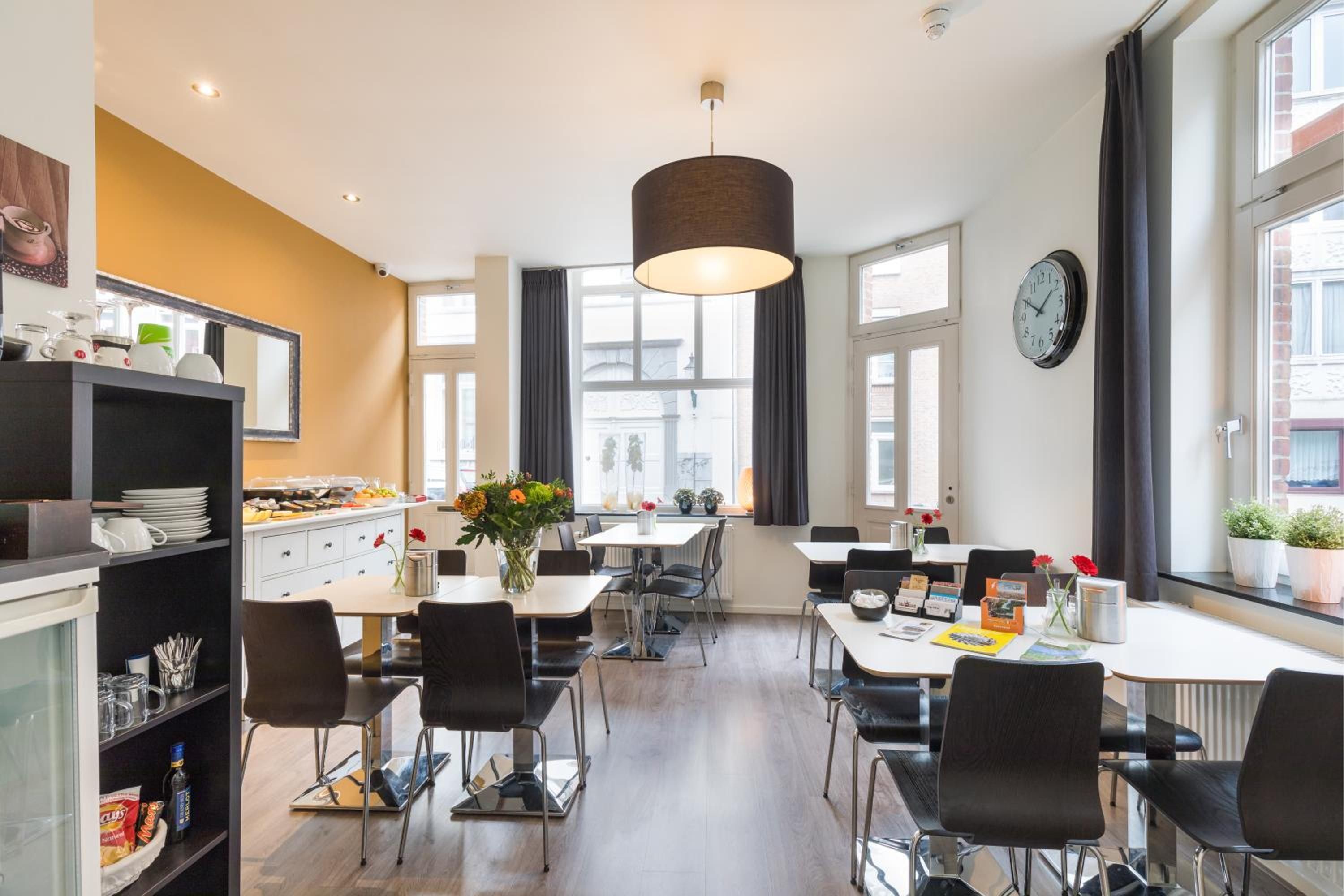 Uma sala de jantar moderna com uma mesa central, cadeiras e um lustre.