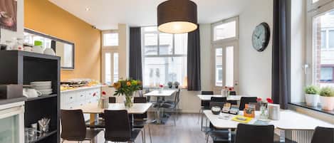 Un comedor moderno con una mesa central, sillas y una lámpara colgante.