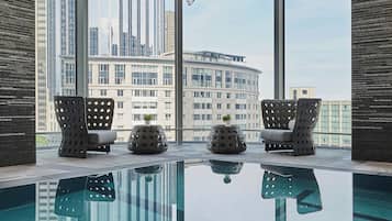 Una piscina techada, sillones reclinables de piscina