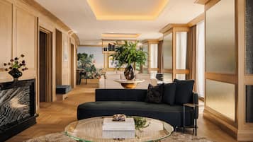 A modern living room with a glass coffee table, a sofa, and a large window.