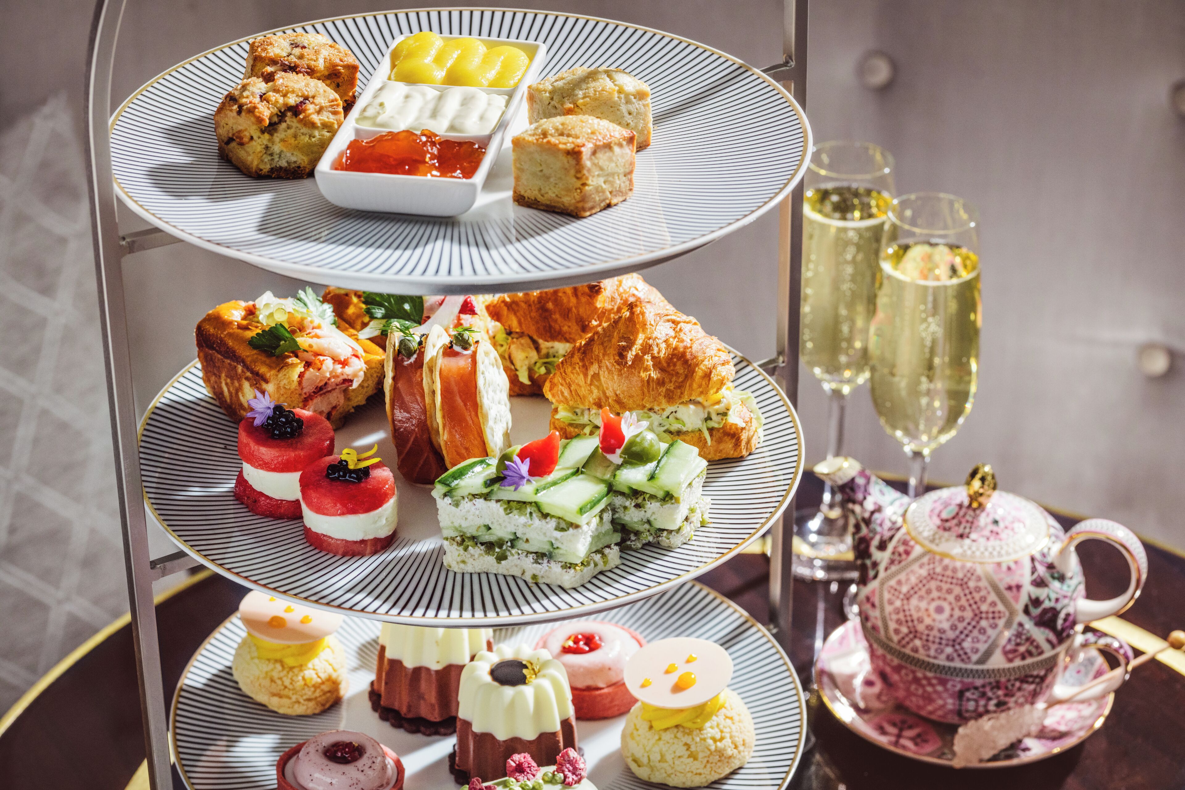 A tiered dessert display with various pastries and a tea set.