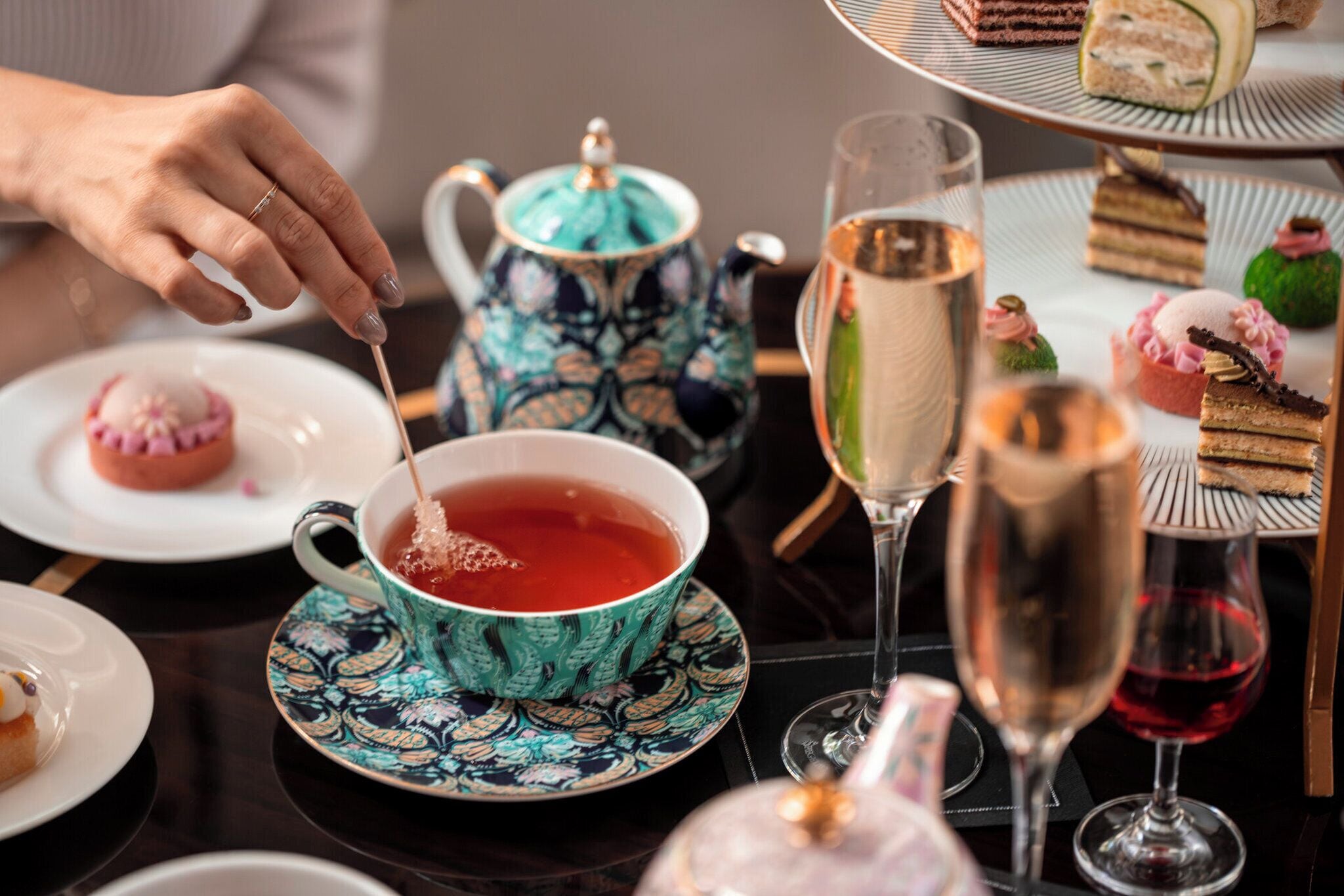 Une table avec une théière, des tasses à thé et divers desserts.