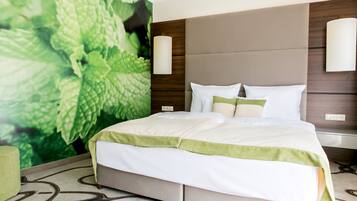 Ein modernes Hotelzimmer mit einem großen Bett, einer grünen Akzentwand und einer Wandlampe.