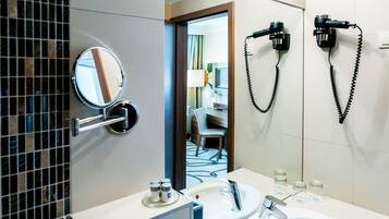 Un baño moderno con un espejo grande, dos lavamanos y un secador de pelo montado en la pared.