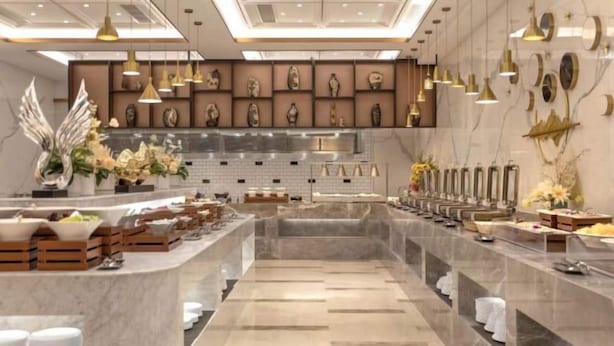 A modern hotel lobby with a central marble reception desk, multiple service counters, and a decorative wall with framed artwork. - Zhenbao Holiday Hotel (Nanjing Olympic Sports Center) (Nanjing)