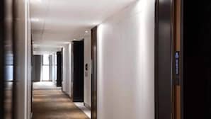 A modern hotel corridor with a wooden floor, white walls, and a series of doors leading to rooms. - Zhenbao Holiday Hotel (Nanjing Olympic Sports Center) (Nanjing)