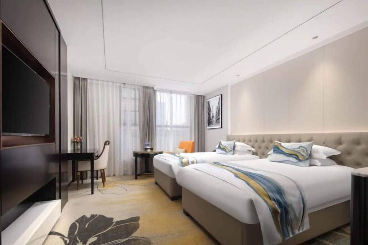 Een moderne hotelkamer met een groot bed, een bureau en een televisie.