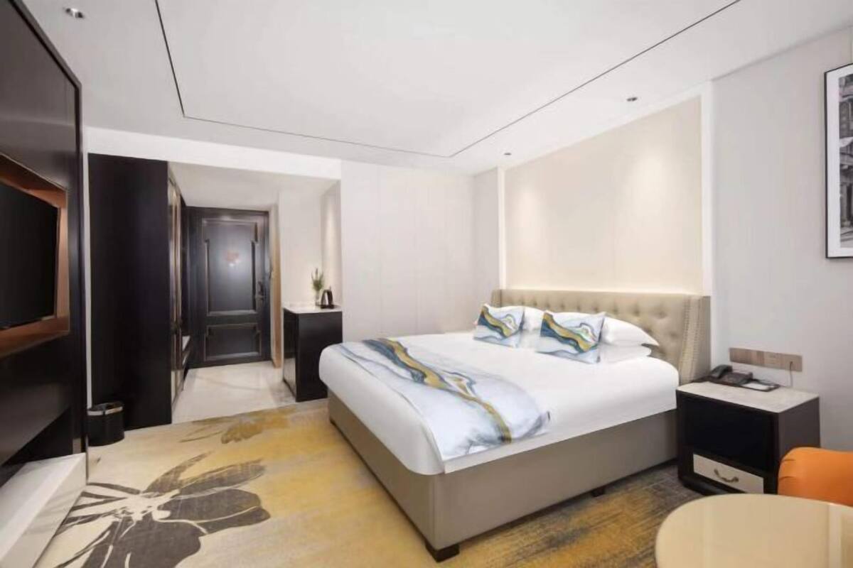 Een moderne hotelkamer met een groot bed, een nachtkastje, een stoel en een televisie.