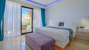 Ein modernes Hotelzimmer mit einem großen Bett, einer Bank, einem Nachttisch und Blick ins Freie.