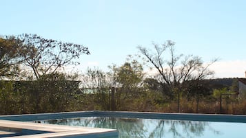 Una piscina al aire libre de temporada, sombrillas