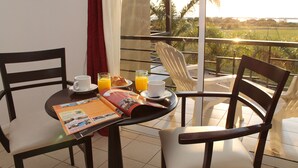 A breakfast setup with a table, chairs, and a view of the outdoors.