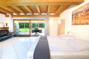 Una habitación con cama, sofá, escritorio y un cuadro en la pared.