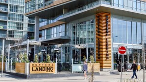 A modern building with a prominent sign for 'Hunters Landing' bar, grill, and hub. - A&A Suites in the heart of Downtown Toronto (Toronto)