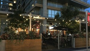 An outdoor seating area with tables and chairs, surrounded by planters with flowers. - A&A Suites in the heart of Downtown Toronto (Toronto)