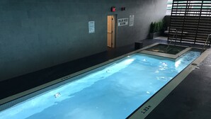 A swimming pool with a tiled edge, a door, and safety signs on the wall. - A&A Suites in the heart of Downtown Toronto (Toronto)