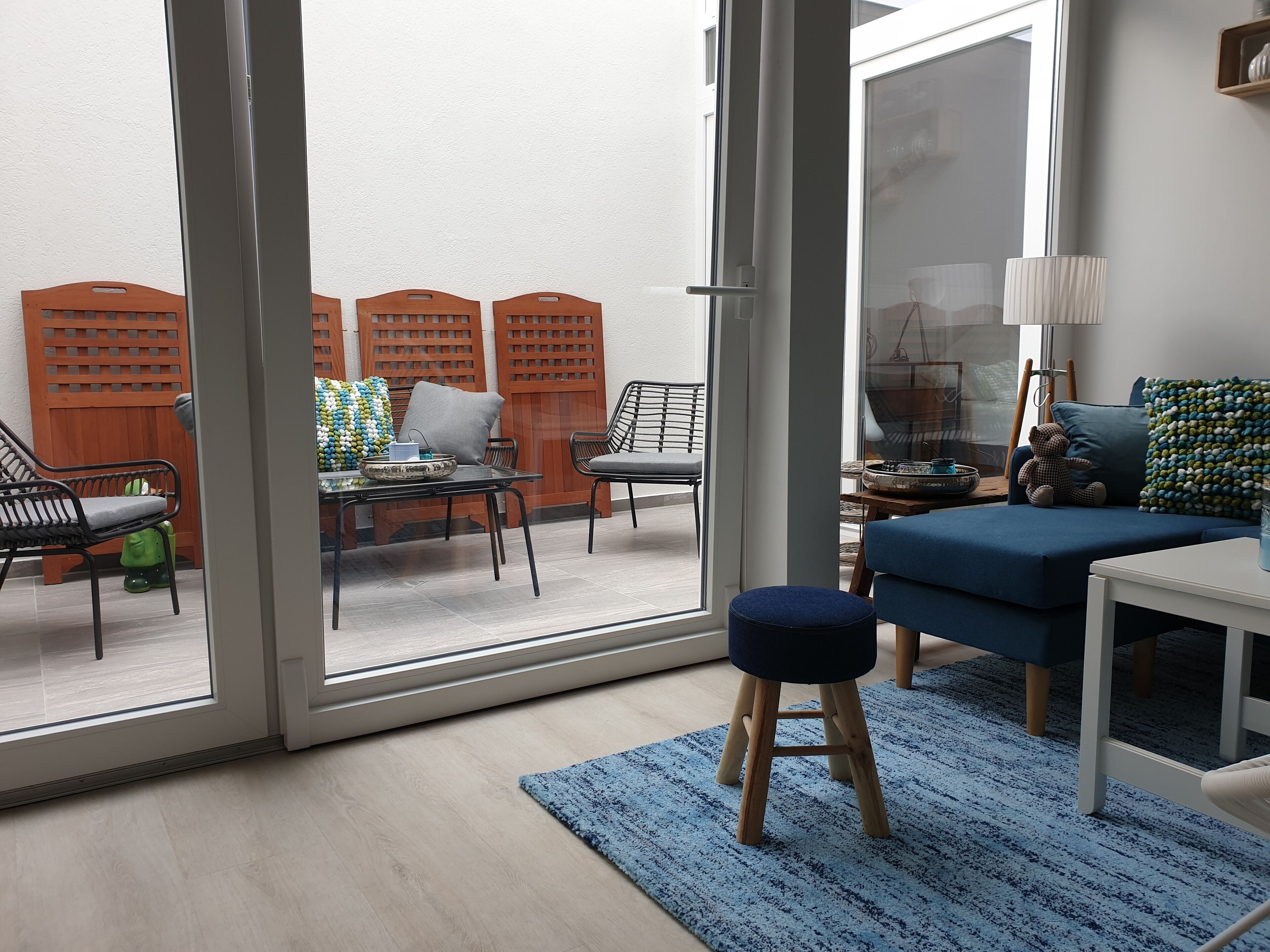 Un salon moderne avec une porte vitrée donnant sur un espace extérieur.