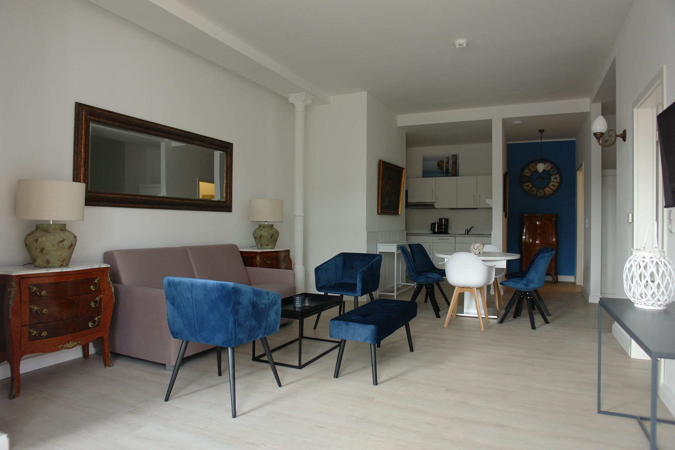 A living room with a sofa, chairs, a coffee table, and a dining area with a table and chairs.