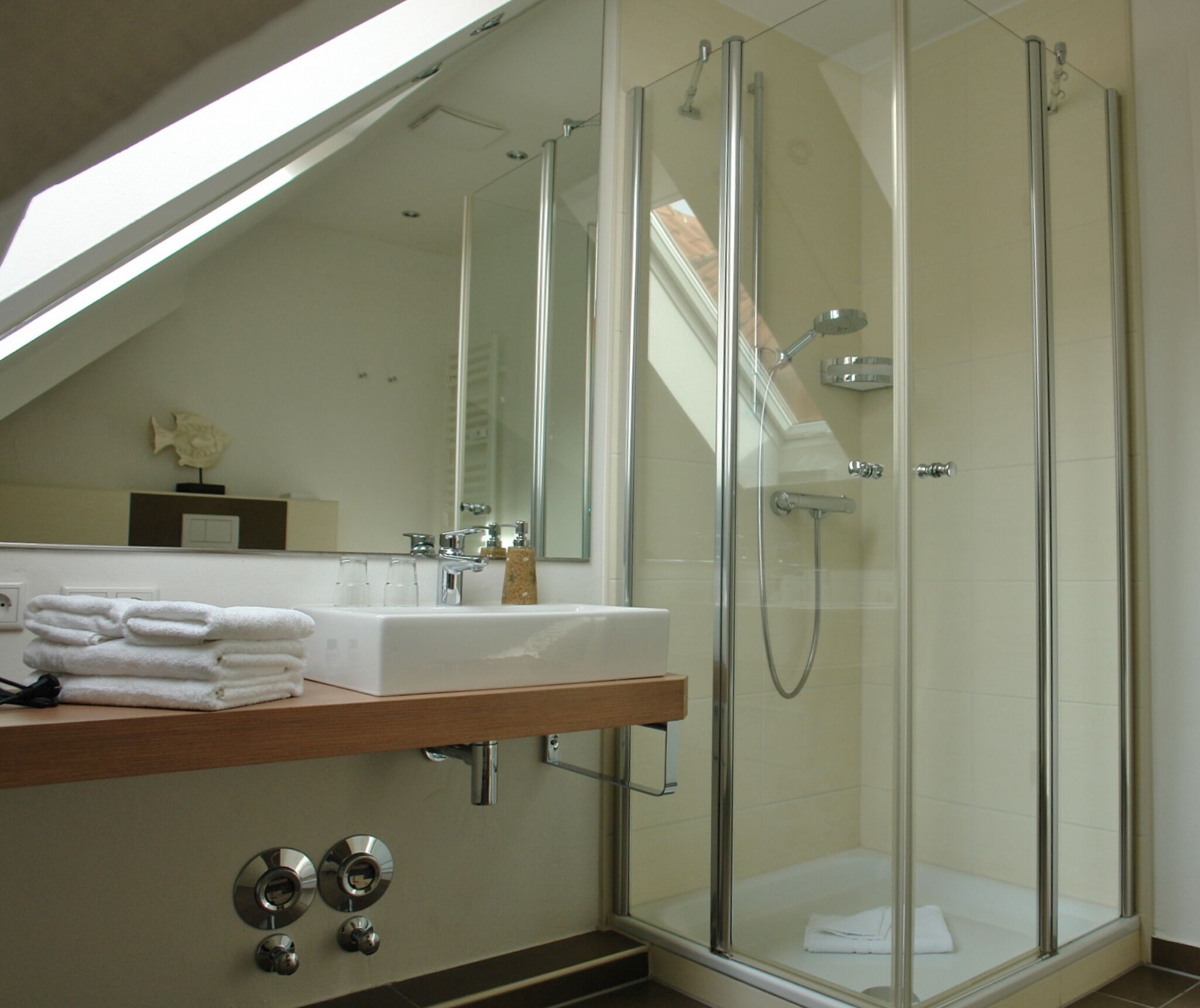 Une salle de bain moderne avec une douche à parois de verre, un meuble-lavabo et un miroir.