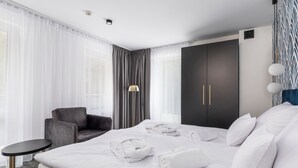 Une chambre d’hôtel avec un lit, une chaise, un bureau et une armoire.