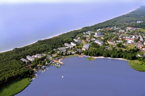 An aerial view of a lakeside town with residential buildings, a marina, and a beach.