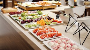 Une table de buffet proposant une variété de plats, notamment des salades, des viandes et des plats à base de riz.