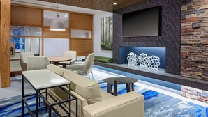 A modern lounge area with a sofa, tables, and a fireplace. - Fairfield Inn & Suites by Marriott Memphis Collierville (Collierville)
